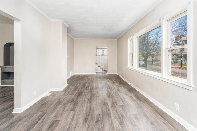 empty room with crown molding and hardwood / wood-style floors