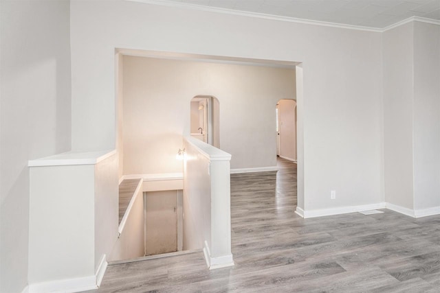 spare room featuring crown molding and wood-type flooring