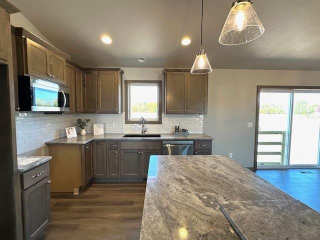 kitchen featuring appliances with stainless steel finishes, hanging light fixtures, a healthy amount of sunlight, and sink