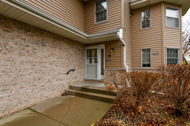 view of exterior entry with brick siding