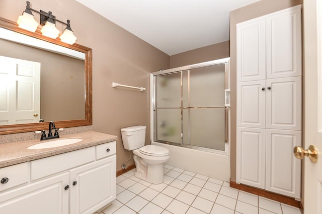 bathroom with tile patterned flooring, enclosed tub / shower combo, vanity, and toilet