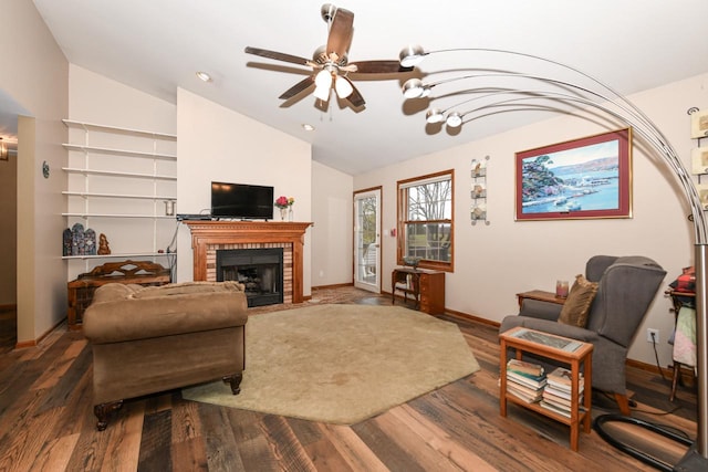 living room with dark hardwood / wood-style flooring, a brick fireplace, ceiling fan, and lofted ceiling