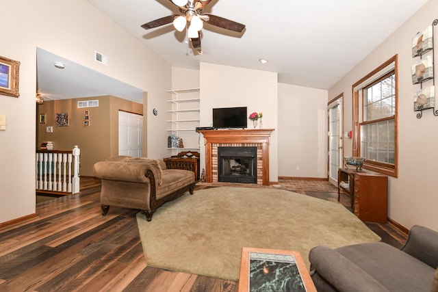 living area with lofted ceiling, a fireplace, wood finished floors, and visible vents