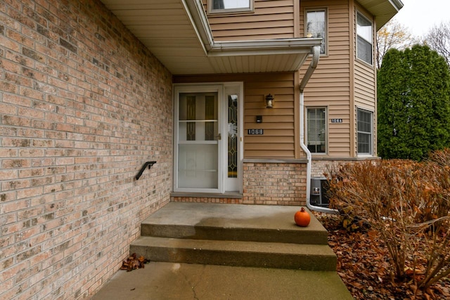 view of exterior entry featuring brick siding