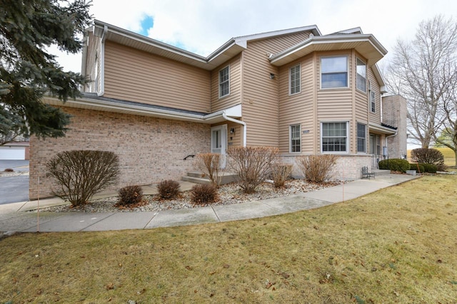 view of side of home with a yard and brick siding