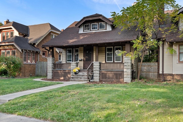 craftsman-style house featuring a porch and a front lawn