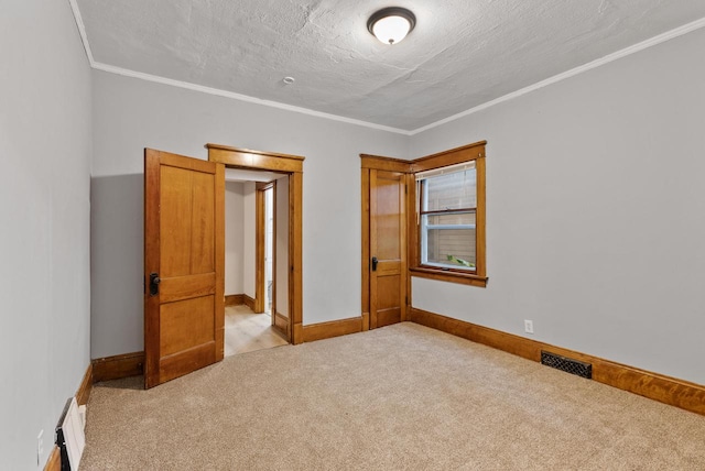 unfurnished bedroom featuring light carpet, crown molding, and a textured ceiling