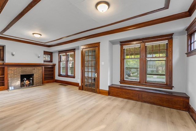 unfurnished living room with light wood-type flooring, a brick fireplace, and crown molding