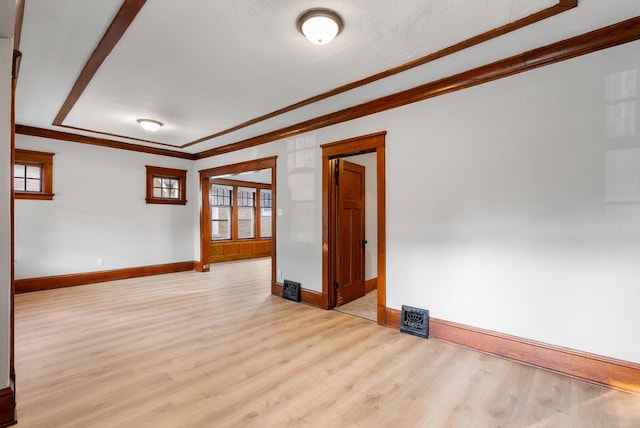 unfurnished room with crown molding, light hardwood / wood-style flooring, a healthy amount of sunlight, and a textured ceiling