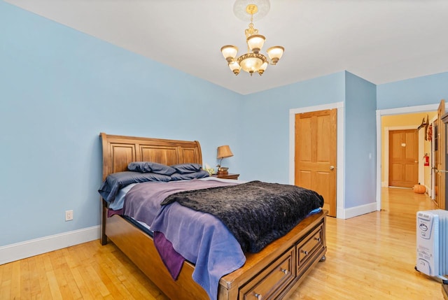 bedroom featuring light wood-type flooring and a notable chandelier