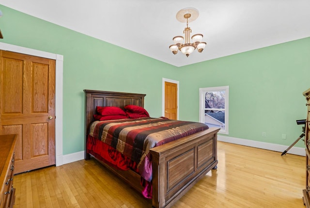 bedroom with light hardwood / wood-style floors and a notable chandelier