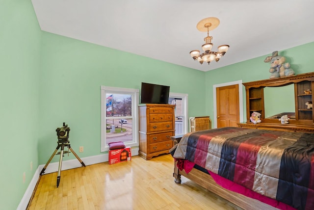 bedroom featuring light hardwood / wood-style flooring and a notable chandelier