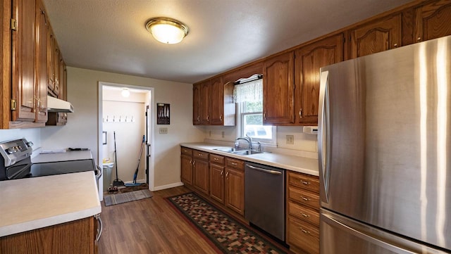 kitchen featuring a textured ceiling, sink, appliances with stainless steel finishes, and dark wood-type flooring