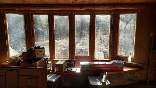 sunroom / solarium featuring beamed ceiling, wood ceiling, and a wealth of natural light