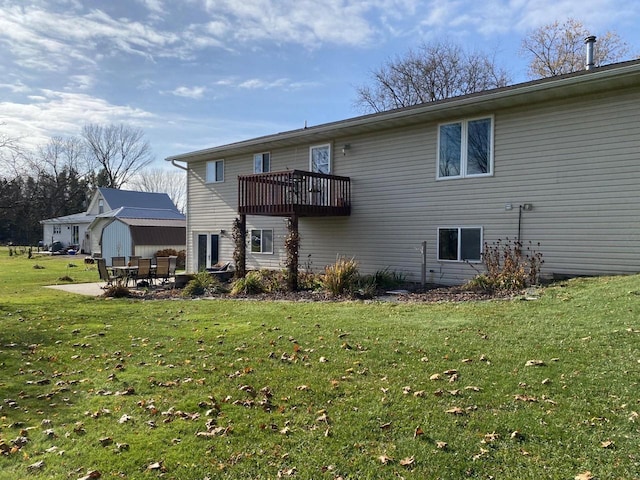 rear view of property with a balcony, a yard, and a patio