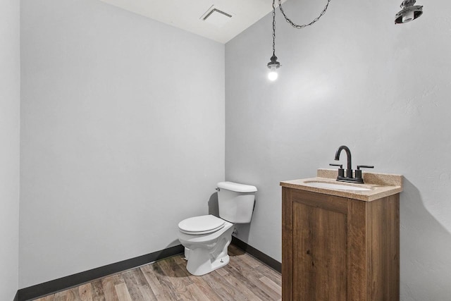 bathroom featuring hardwood / wood-style flooring, vanity, toilet, and lofted ceiling