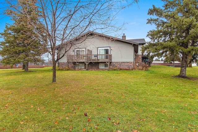 rear view of house with a lawn and a deck