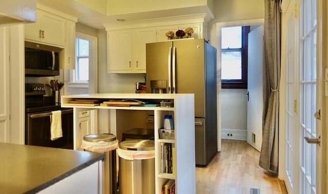 kitchen featuring stainless steel appliances, white cabinetry, and light hardwood / wood-style floors