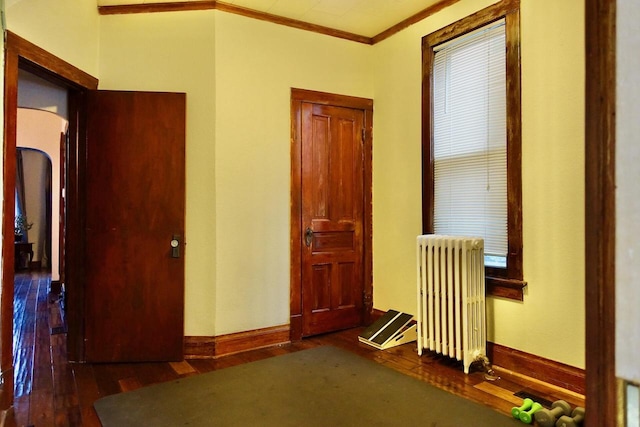 interior space featuring radiator, dark hardwood / wood-style flooring, and ornamental molding