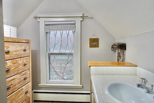 bathroom featuring vanity, a textured ceiling, lofted ceiling, and a baseboard heating unit