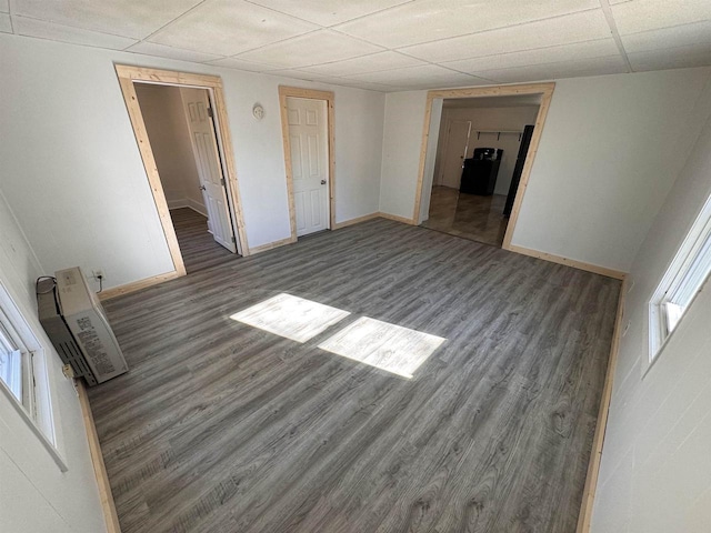 interior space with multiple windows, a paneled ceiling, and dark hardwood / wood-style floors