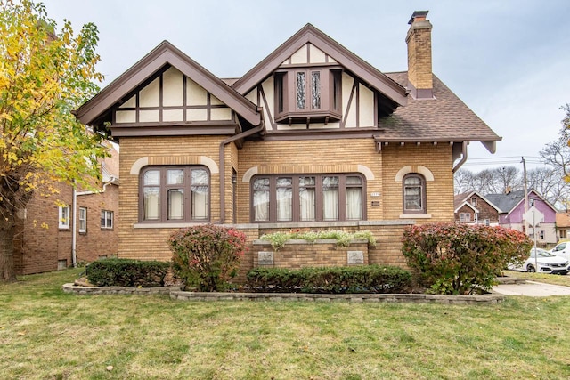 english style home featuring a front yard