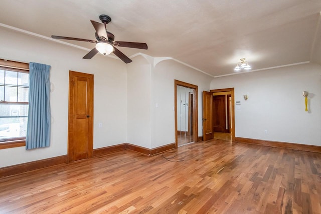 spare room with ceiling fan, crown molding, and light wood-type flooring