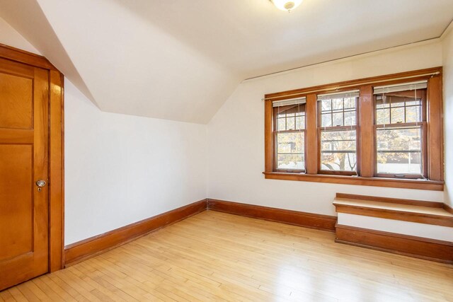 additional living space with plenty of natural light, vaulted ceiling, and light wood-type flooring