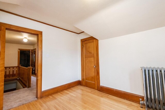 bonus room with radiator and light hardwood / wood-style floors