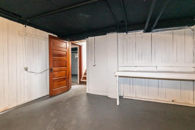 basement featuring wood walls