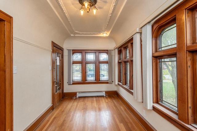 unfurnished sunroom featuring a tray ceiling and a baseboard radiator