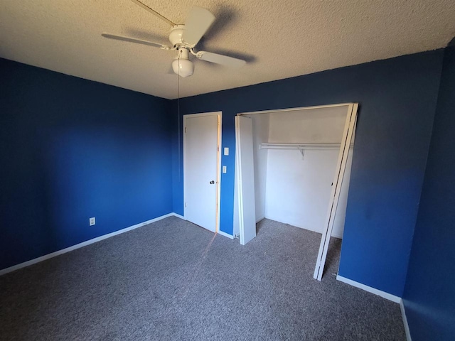 unfurnished bedroom with ceiling fan, a closet, a textured ceiling, and dark colored carpet