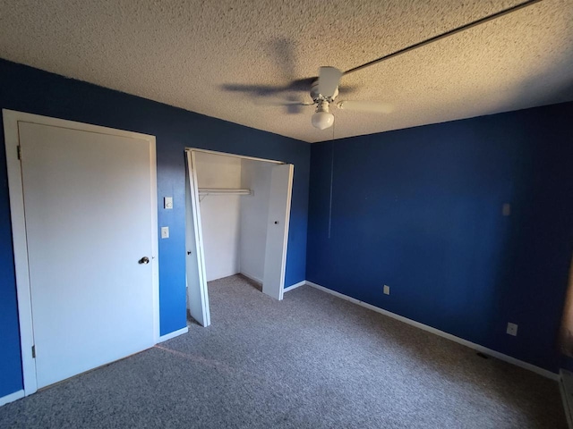 unfurnished bedroom featuring carpet, a textured ceiling, a closet, and ceiling fan