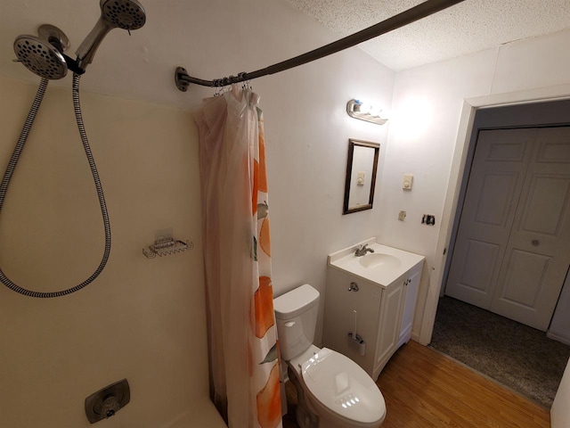 bathroom featuring wood-type flooring, a textured ceiling, toilet, vanity, and a shower with shower curtain