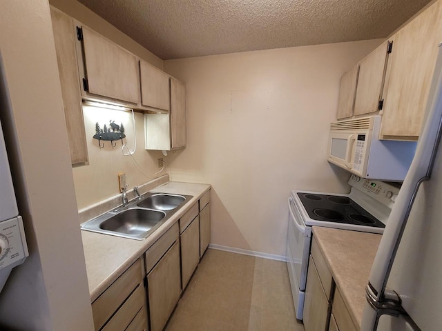 kitchen featuring a textured ceiling, light brown cabinetry, white appliances, and sink