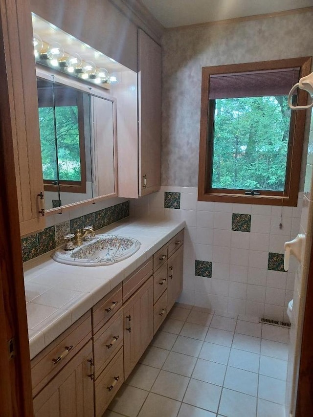 bathroom featuring tile patterned flooring, vanity, and tile walls