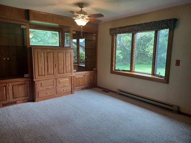 unfurnished bedroom with a textured ceiling, ceiling fan, light carpet, and a baseboard radiator