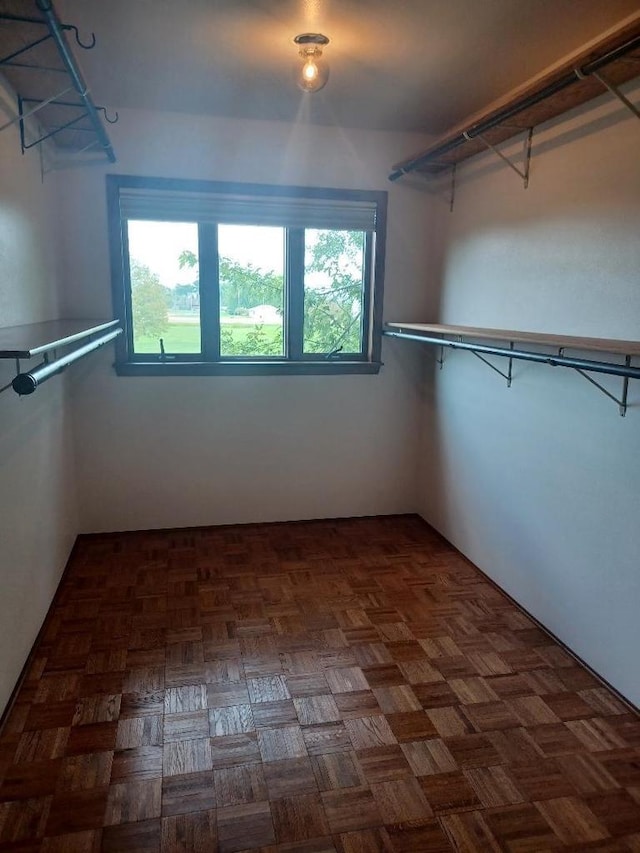 spacious closet featuring dark parquet flooring