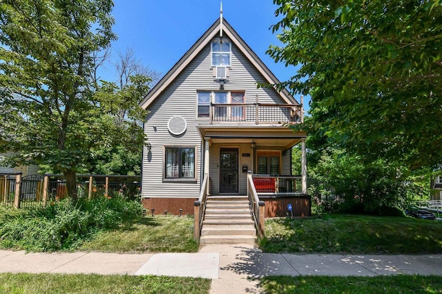 view of front of house featuring a balcony, covered porch, and a front yard