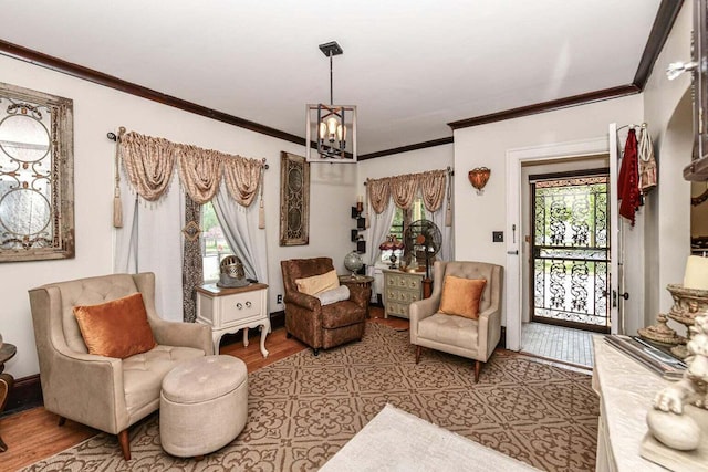 living area featuring an inviting chandelier, light hardwood / wood-style flooring, and ornamental molding