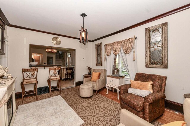 sitting room featuring light hardwood / wood-style flooring and ornamental molding