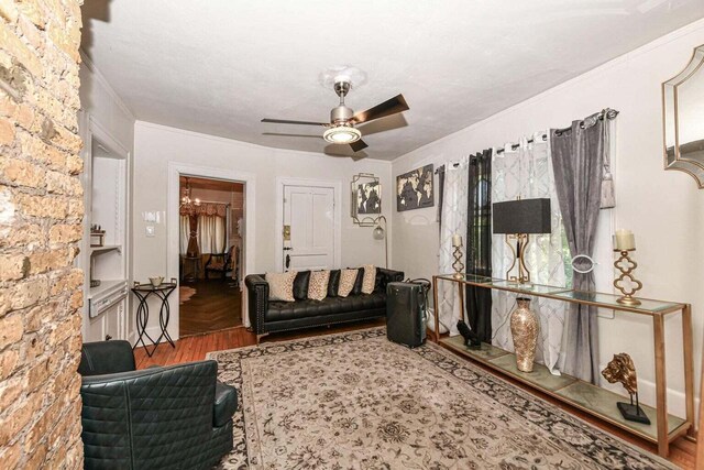 living room with crown molding, ceiling fan, and hardwood / wood-style flooring