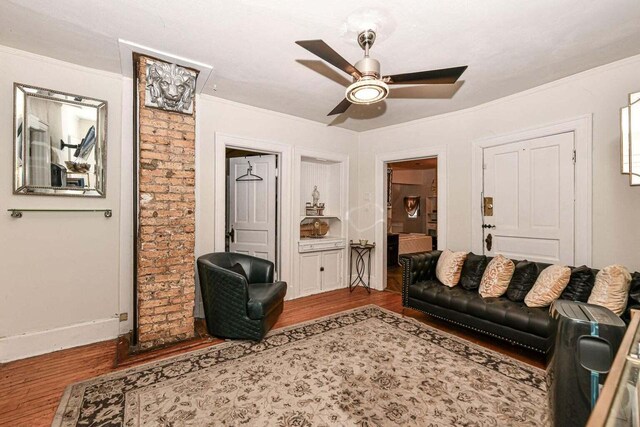 living room featuring crown molding, ceiling fan, and light wood-type flooring