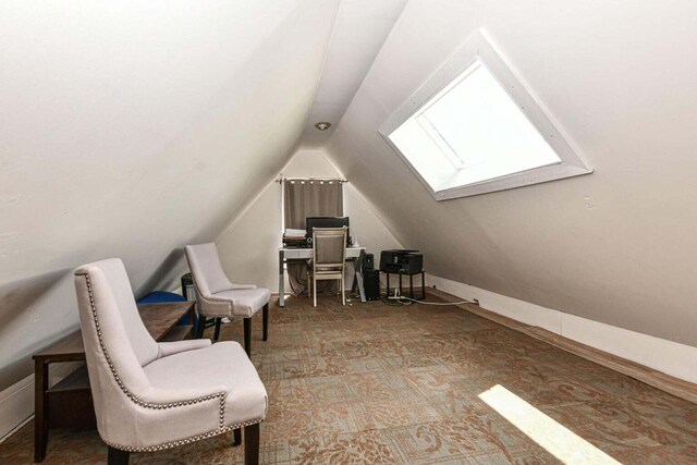 sitting room featuring vaulted ceiling and carpet