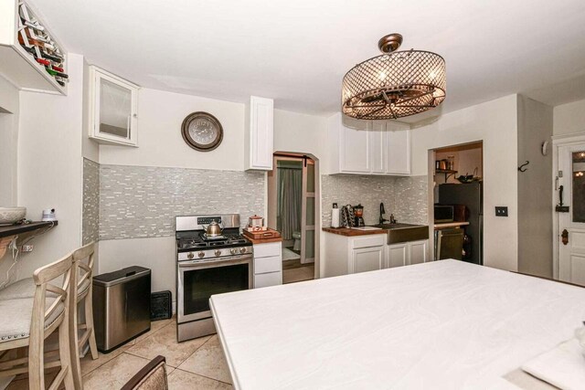 kitchen featuring stainless steel appliances, white cabinetry, tasteful backsplash, and sink