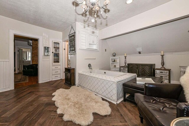 bedroom featuring an inviting chandelier, dark parquet floors, and a textured ceiling