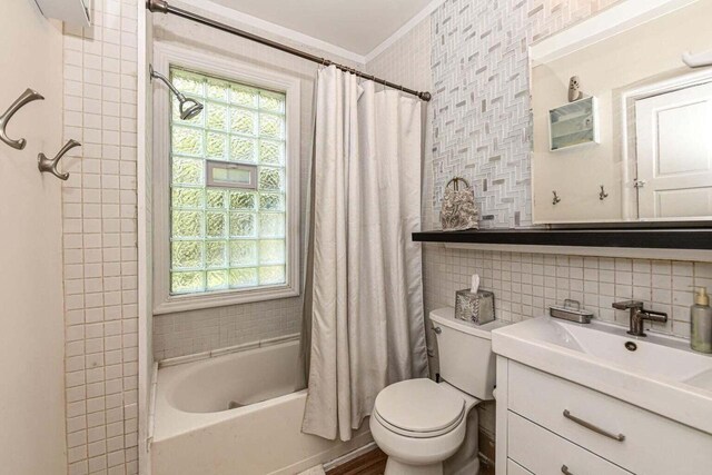 full bathroom with a wealth of natural light, tile walls, vanity, and toilet