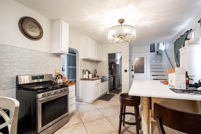330 E Locust St, Milwaukee, WI 53212 - kitchen featuring stainless steel appliances, backsplash, a sink, white cabinets, and light tile patterned flooring