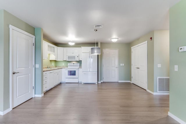 kitchen with sink, light hardwood / wood-style flooring, decorative light fixtures, white appliances, and white cabinets