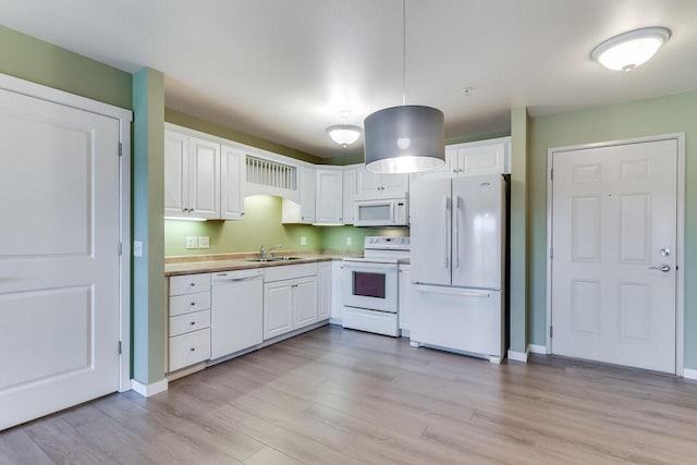 kitchen with white cabinets, light wood-type flooring, white appliances, and sink